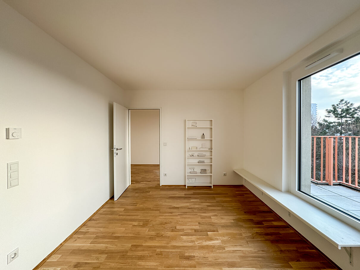 Innovatives Wohnkonzept: Der Wohnraum der Musterwohnung mit sitzhoher Fensterbank, die den Essbereich elegant definiert.