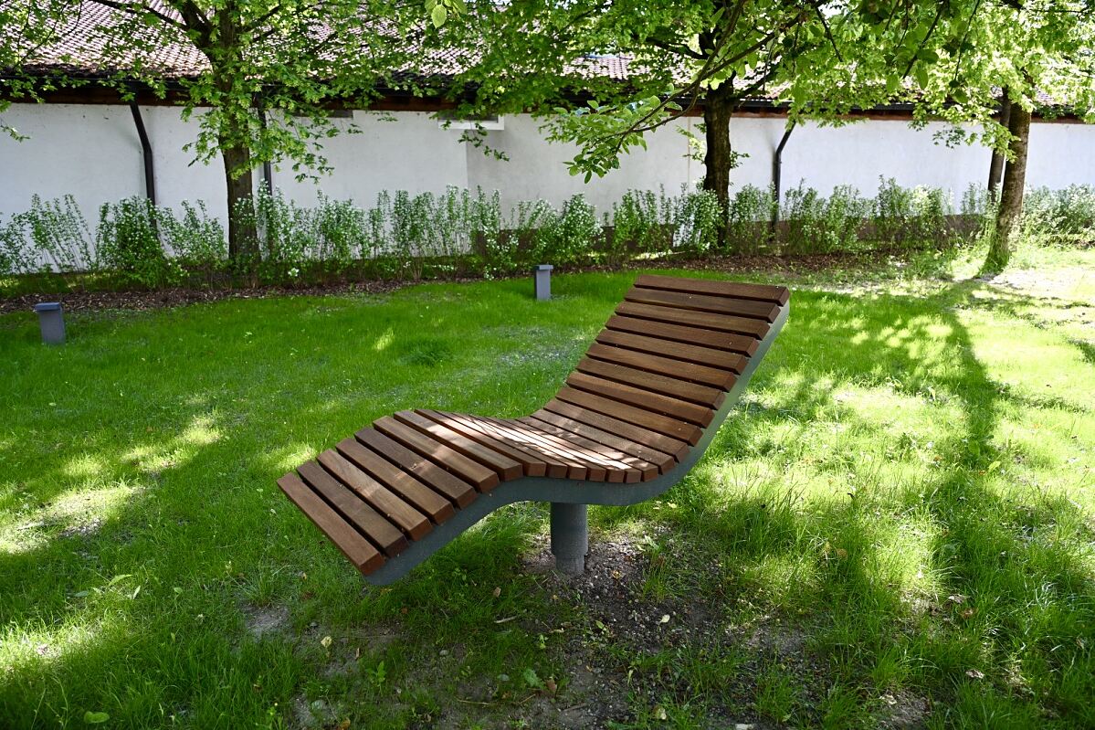 Entspannung im Grünen: Ein Liegestuhl im begrünten Außenbereich lädt zum Abschalten und Genießen der Ruhe ein.