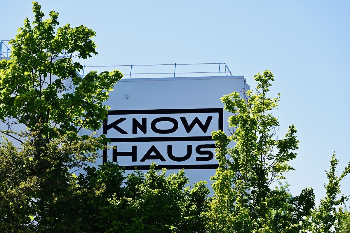 Das neue Knowhaus-Branding, elegant eingerahmt von Baumkronen, symbolisiert die Verbindung von Innovation und Natur.