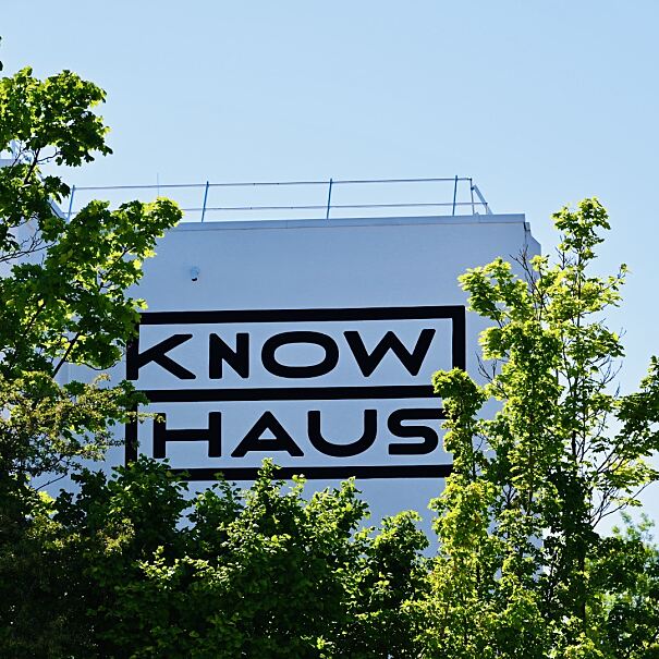 Das neue Knowhaus-Branding, elegant eingerahmt von Baumkronen, symbolisiert die Verbindung von Innovation und Natur.